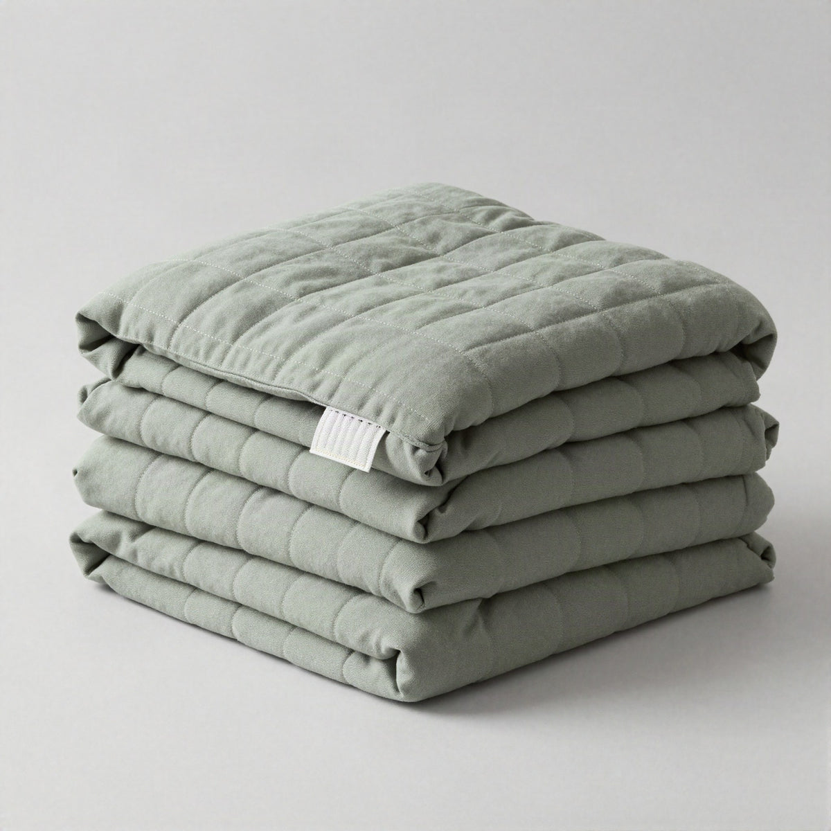 Calming weighted blanket draped over a sofa in golden light